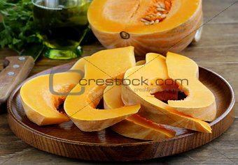fresh raw pumpkin sliced ​​on a wooden table