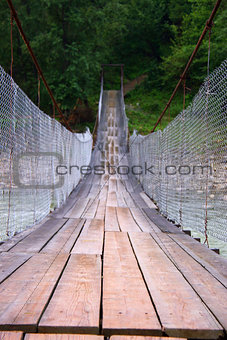 Suspension bridge across mountain river