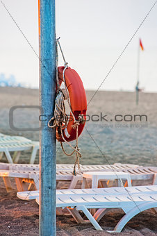 Lifebuoy hanging on a pole on the public beach.