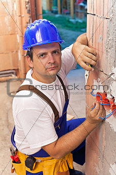 Electrician installing wires in a new building