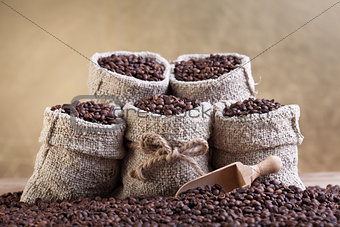 Roasted coffee beans in small burlap bags
