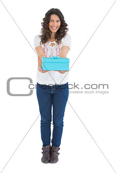 Cheerful casual brunette offering a present