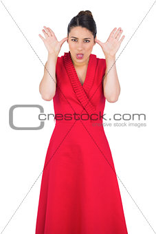 Elegant model in red dress making faces