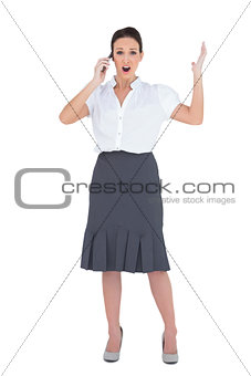 Shocked businesswoman having a phone call