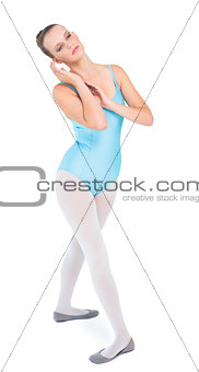 Unsmiling pretty ballerina posing touching her ear