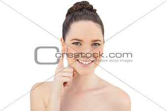 Cheerful natural model applying cream on her crows feet