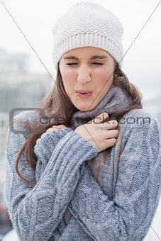 Shivering cute woman with winter clothes on posing