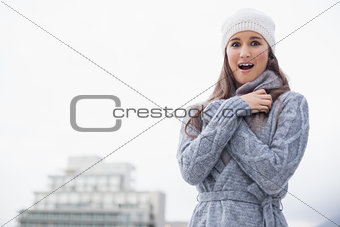 Surprised young woman with winter clothes on posing