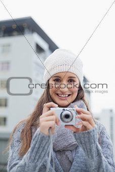 Cheerful gorgeous woman with winter clothes on taking picture