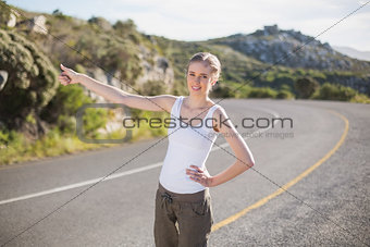 Stranded woman hitching a lift and smiling at camera