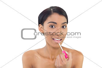 Pretty natural model applying glossy lipstick