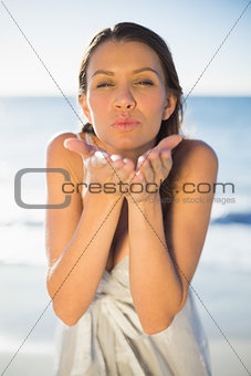 Brunette woman blowing an air kiss