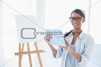 Happy attractive artist using her tablet pc