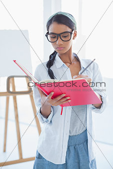 Concentrated attractive artist drawing on her notebook