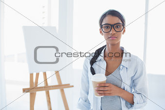 Cheerful attractive artist holding cup of coffee