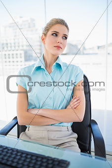 Thoughtful classy businesswoman crossing arms