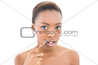 Beautiful model pointing at her mouth