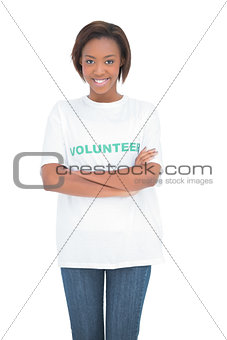 Smiling volunteer woman standing crossing arms