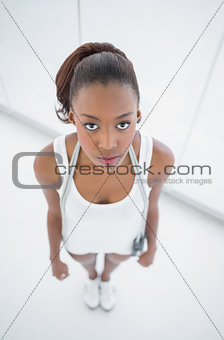 Peaceful fit woman holding skipping rope on shoulders