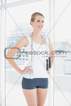 Cheerful sporty woman holding skipping rope