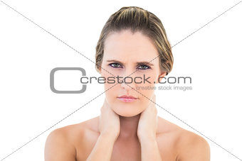 Disgruntled woman looking at camera with a sore neck