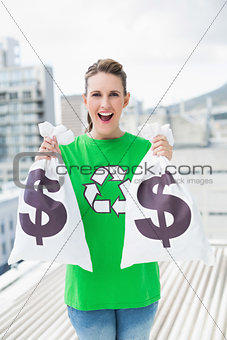 Cheerful woman in green recyling tshirt showing money bags