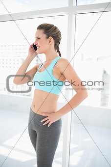 Fit woman in sportwear talking on the phone