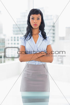 Serious businesswoman posing and crossing her arms