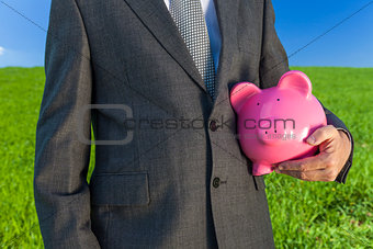 Man Businessman Holding Piggy Bank in Field