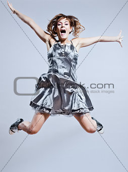 beautiful young girl with prom dress jumping screaming happy