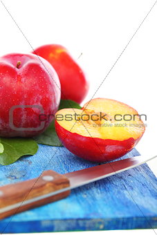 Ripe plums and knife.