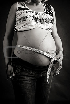 pregnant woman tenderly measuring her tummy