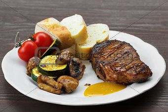 pork steak with sauce, mustard and grilled vegetables