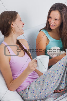 Two girls sitting on bed