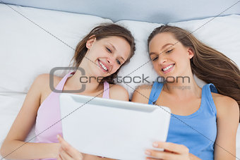 Friends looking at tablet and laughing