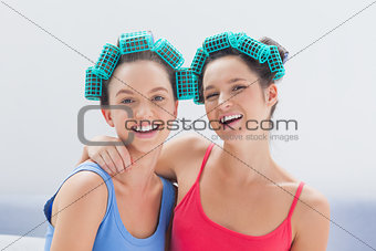 Girls in hair rollers and pajamas smiling at camera