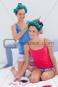 Girls in hair rollers and pajamas chatting