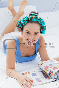 Girl in hair rollers lying in bed
