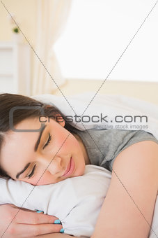 Smiling girl sleeping in her bed