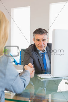 Amused businessman shaking the hand of a interviewee