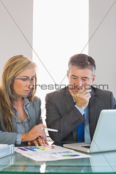 Two thoughtful businesspeople trying to understand figures