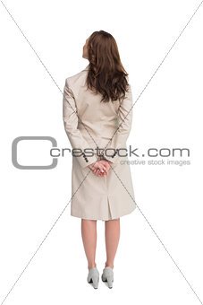 Rear view of businesswoman crossing hands behind back