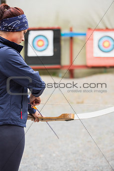 Brunette preparing her bow and arrow