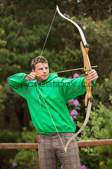 Focused man practicing archery