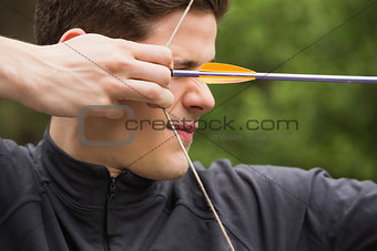 Concentrated man practicing archery