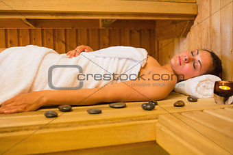 Peaceful brunette woman lying in a sauna