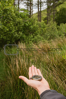 Female hand holding old fashioned compass showing the way