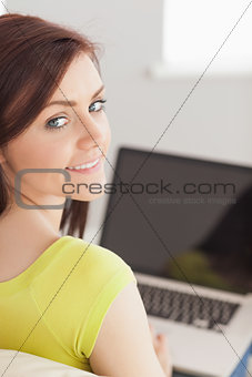 Content girl sitting on a sofa using a laptop