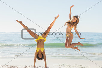 Friends in bikinis jumping and doing handstand