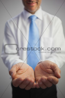 Close up of a content businessman joining his hands to the camera